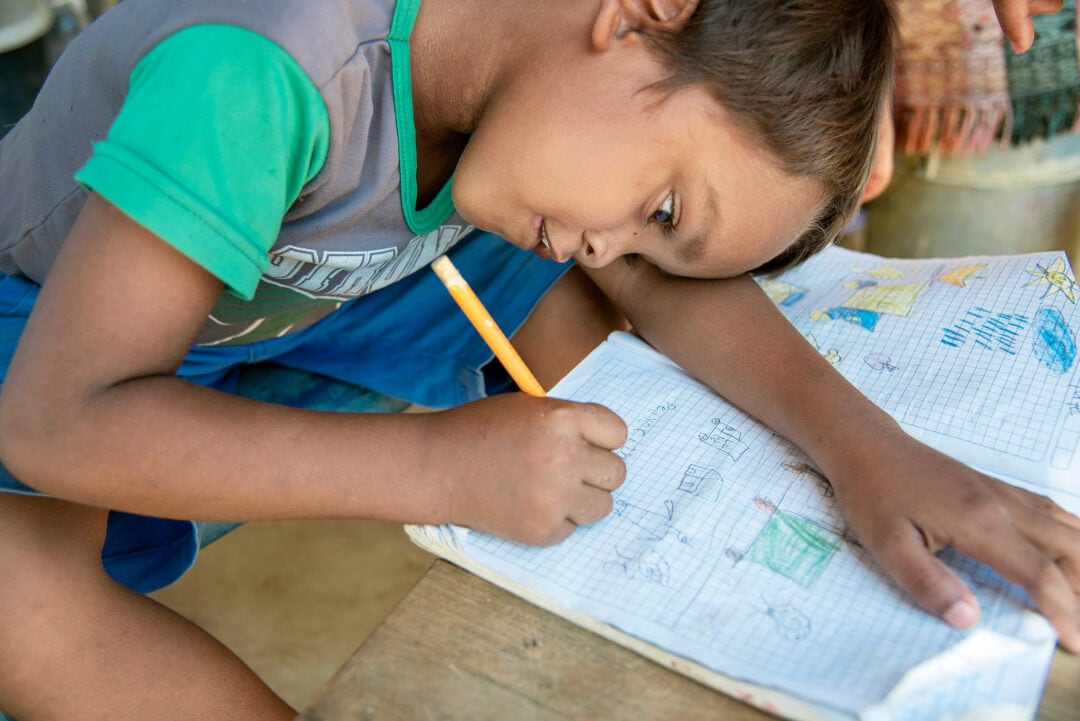 Pedro draws at this family's home in the April Third refugee camp. Photo: Rohanna Mertens