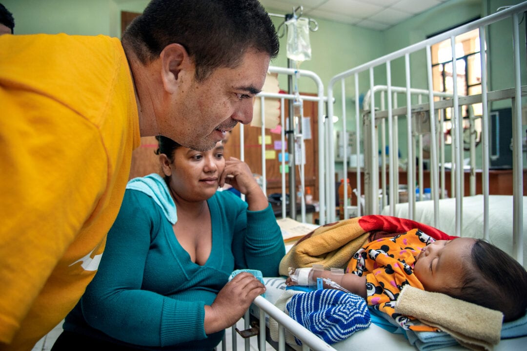 Patient Advocate Alex Guerrero looks at six-month-old Erick as he sleeps after cleft surgery. Photo: Rohanna Mertens