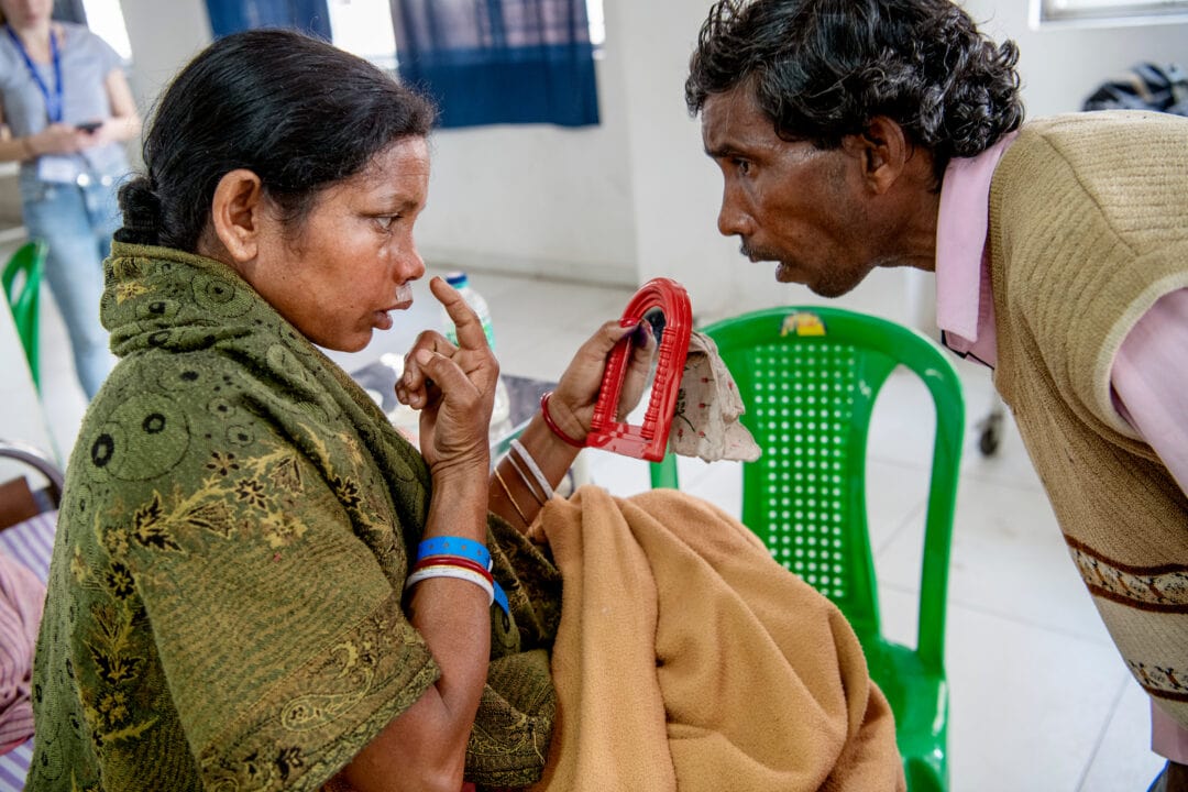 34-years-old Allo looks at herself for the first time after cleft surgery in india. Photo: Malin Hoelstad