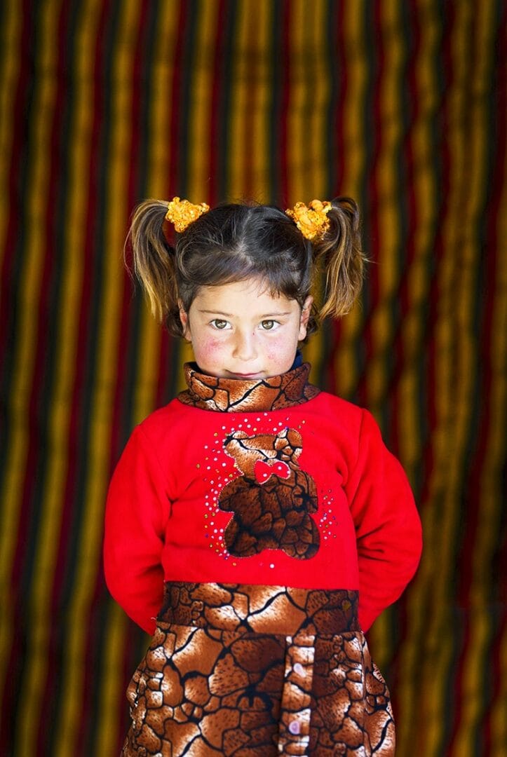 Rana in a red cardigan, looks at the camera, after cleft surgery. Photo: Rae Ceretto.