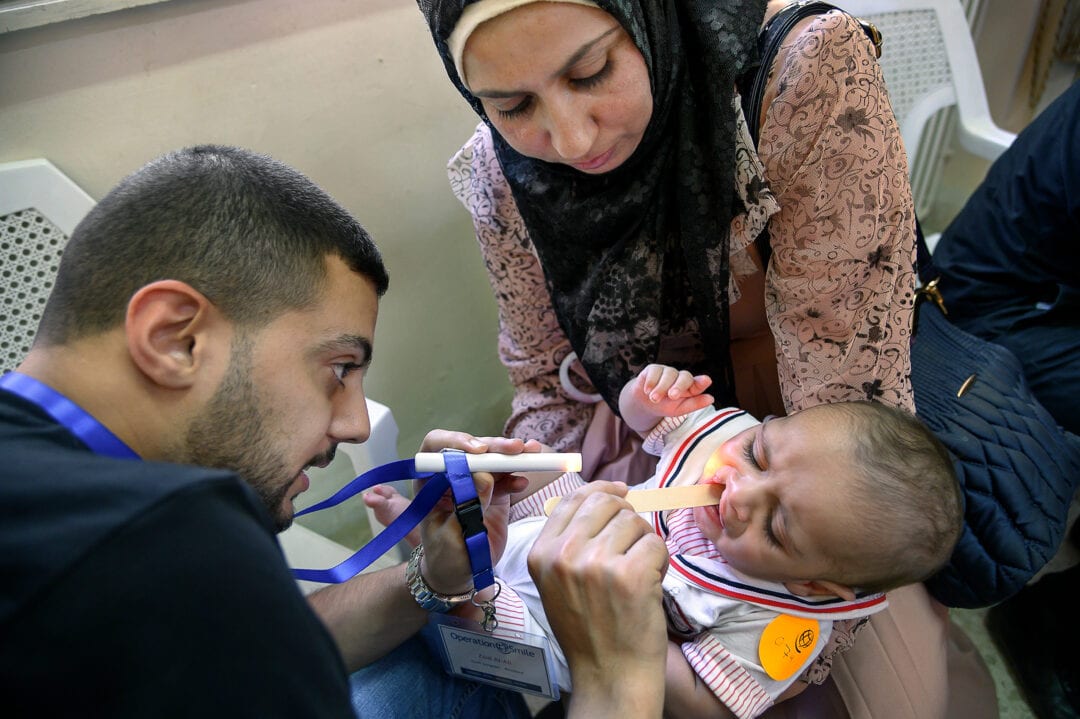 Jordanian Volunteer Cleft Surgeon Resident Zaid Al- Ali examines eight-month-old Eisa. Photo: Rohanna Mertens