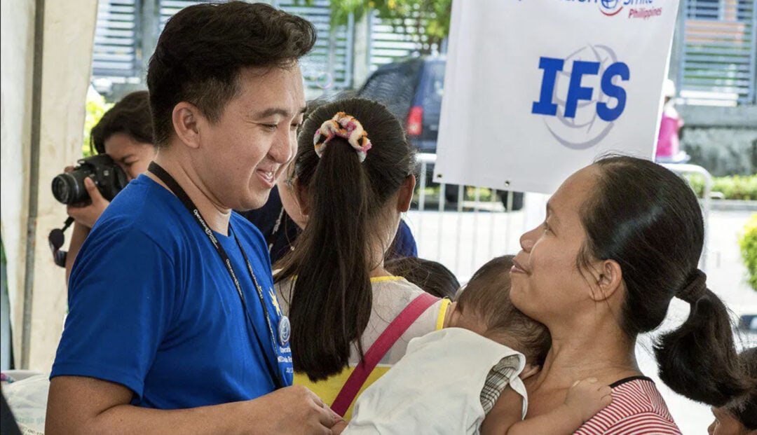 Operation Smile volunteer and IFS team member JR Lado speaks to the family member of a potential patient