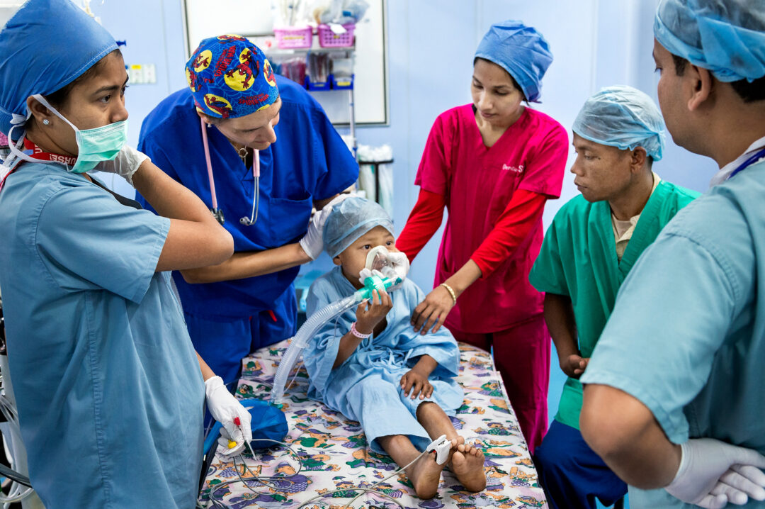 Medical volunteer staff with patient, India 2013. Photo: Alan Hill