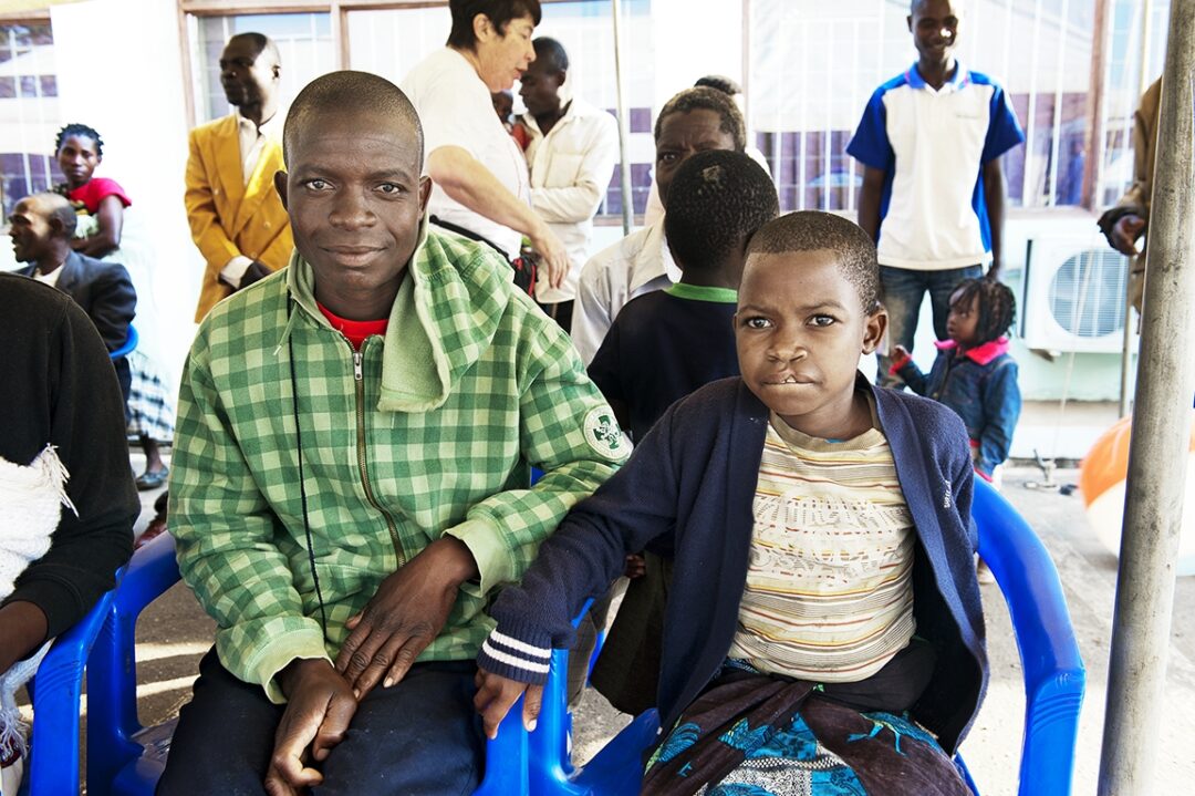 Waiting patiently, Jangiya sits beside Mina during screening day during Operation Smile Malawi’s 2015 surgical programme. Photo: Margherita Mirabella.