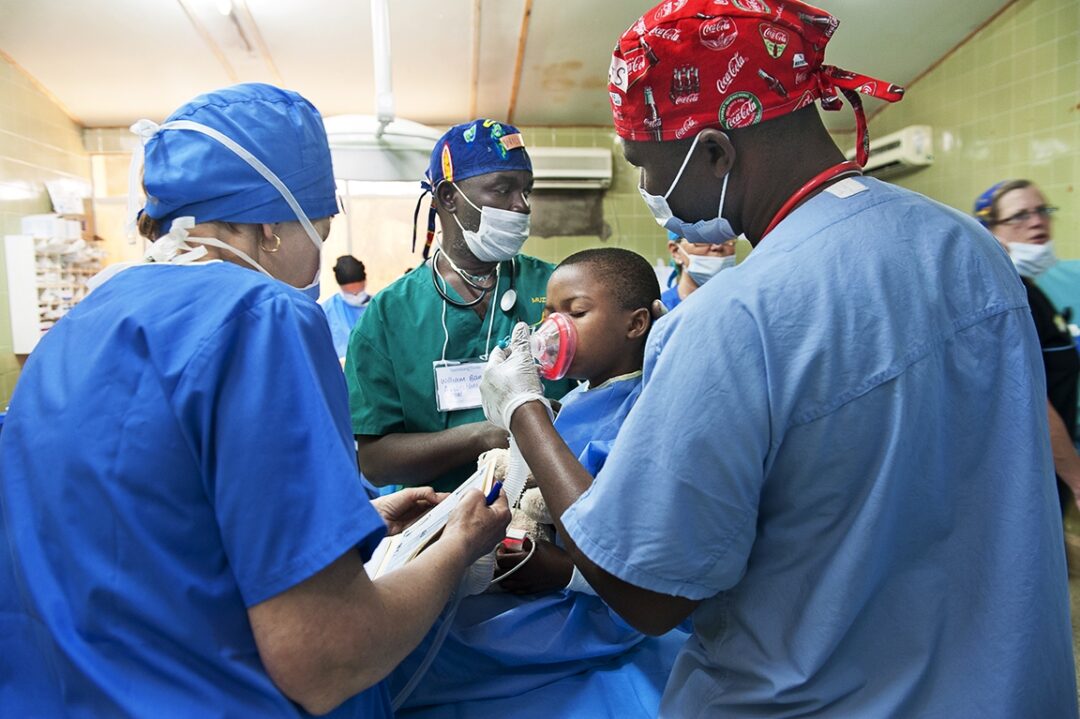 Volunteer Anaesthesiologist Dr. William Banda from Malawi, centre, and the operating room team prepares Mina for her cleft lip surgery. Photo: Margherita Mirabella.