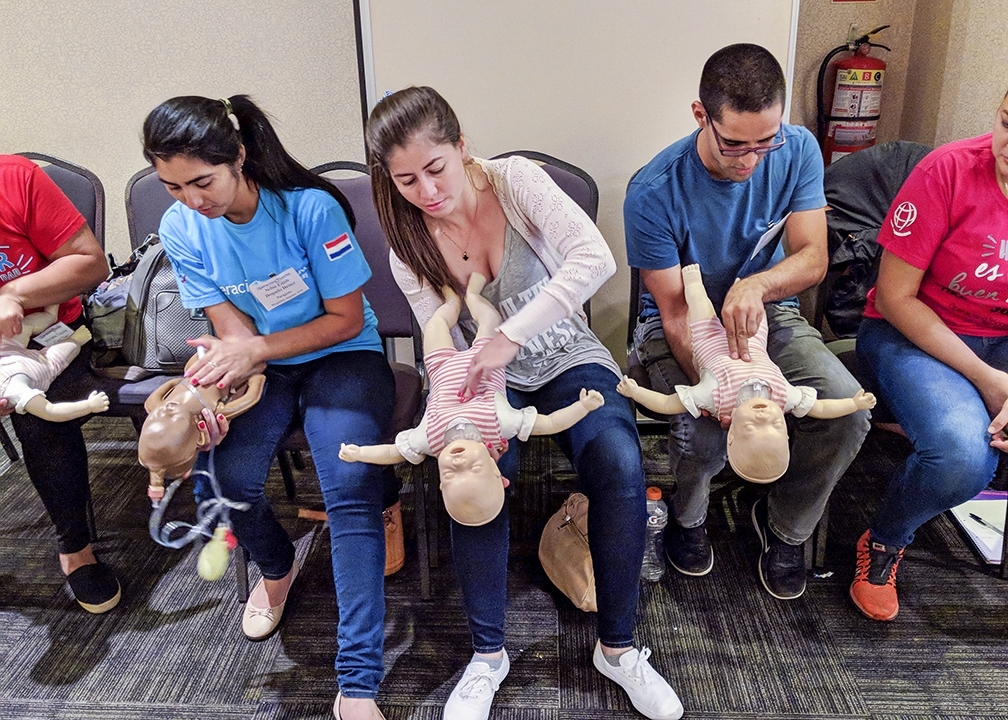 Paraguayan nurses Nilse, left, Fabiola and Luis practice saving a choking infant during a BLS course. Photo: Vania Tally.