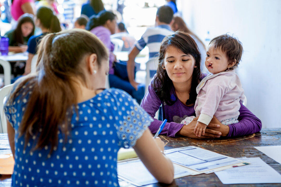 Volunteers assist completing patient information in their medical charts. Asuncion, Paraguay. Photo:  Carlos Rueda